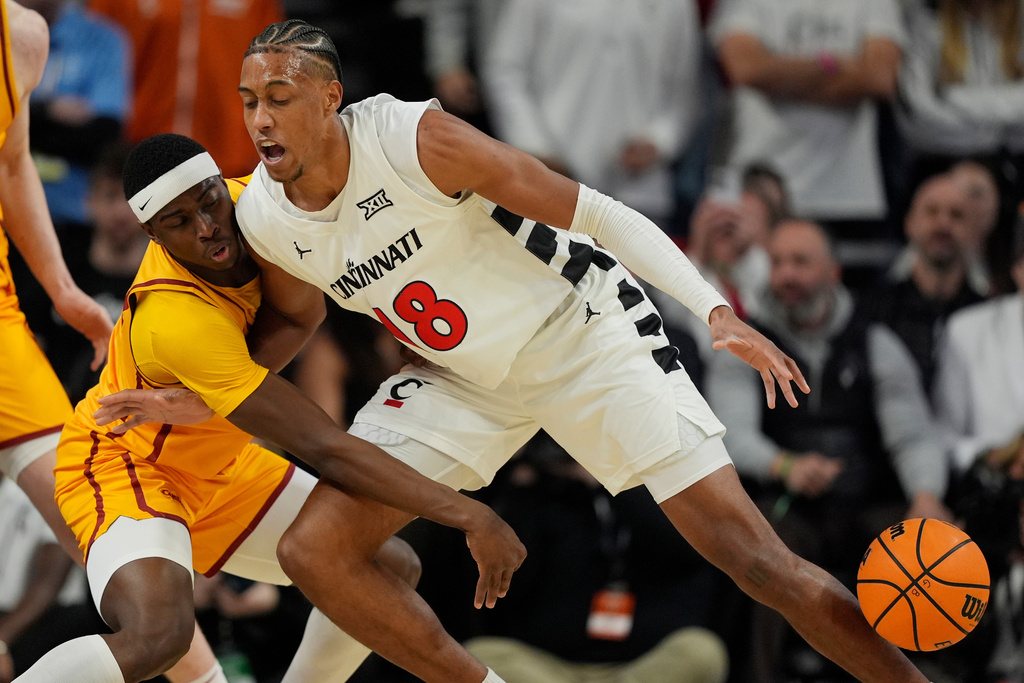 Cincinnati forward Baba Miller, right and Iowa State guard Killyan Toure, left, battle for the ball during the first half of an NCAA college basketball game, Saturday, Jan. 17, 2026, in Cincinnati. (AP Photo/Carolyn Kaster)