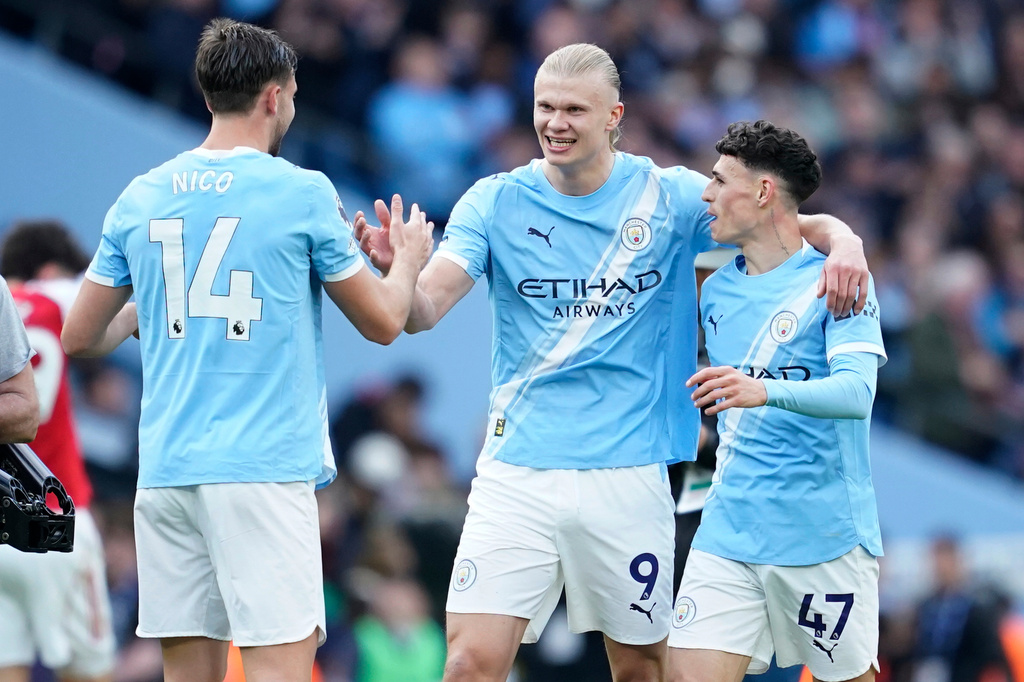 Manchester City's Erling Haaland celebrate with his teammates Nico Gonzalez and Phil Foden at the end of the English Premier League soccer match between Manchester City and and Arsenal, in Manchester, England, Sunday, April 19, 2026. (AP Photo/Dave Thompson)