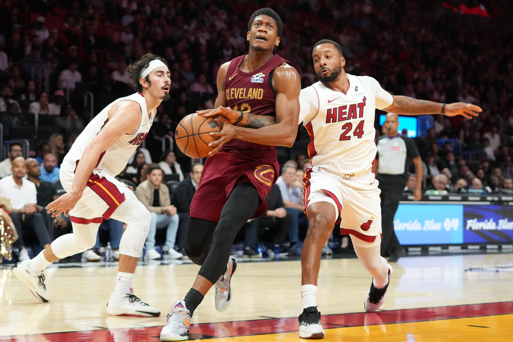 Cleveland Cavaliers forward De'Andre Hunter (12) drives to the basket as Miami Heat guard Norman Powell (24) defends during the second half of an NBA basketball game Monday, Nov. 10, 2025, in Miami. (AP Photo/Marta Lavandier)