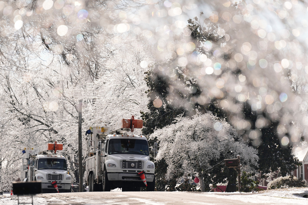 Utility trucks are seen through ice covered trees Wednesday, Jan. 28, 2026, in Nashville, Tenn. after a winter storm passed through area over the weekend. (AP Photo/George Walker IV)