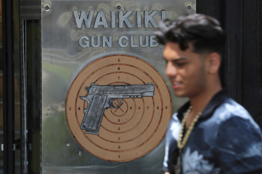 FILE - A pedestrian walks past the Waikiki Gun Club in Honolulu, Thursday, June, 23, 2022. (AP Photo/Marco Garcia)