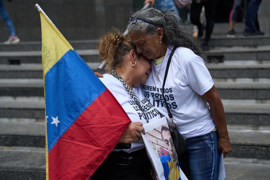 Barbara Bracho, left, mother of Gilberto Bracho, is embraced by Zoraida Gonzalez, mother of Miguel Estrada, both of whom consider their sons to be political prisoners, protest for their releases outside the United Nations office in Caracas, Venezuela, Wednesday Feb. 18, 2026. (AP Photo/Ariana Cubillos)