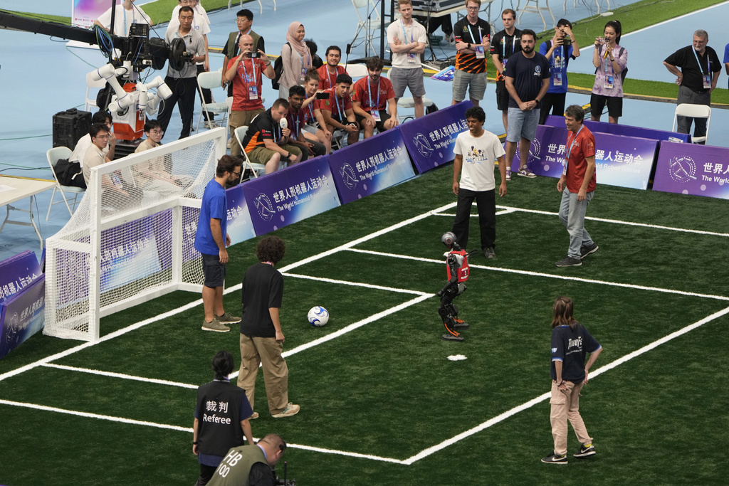 A robot stands in front of the net at a soccer demonstration match between humans vs robots during the closing ceremony of the World Humanoid Robot Games held in Beijing, China, Sunday, Aug. 17, 2025. (AP Photo/Mahesh Kumar A.)