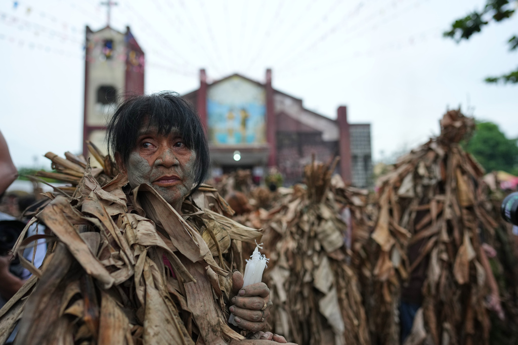 A Catholic devotee covered in mud and dried banana leaves participate in the mud people festival on the feast day of Saint John the Baptist at Bibiclat, Nueva Ecija province, northern Philippines on Wednesday, June 24, 2026. (AP Photo/Aaron Favila)