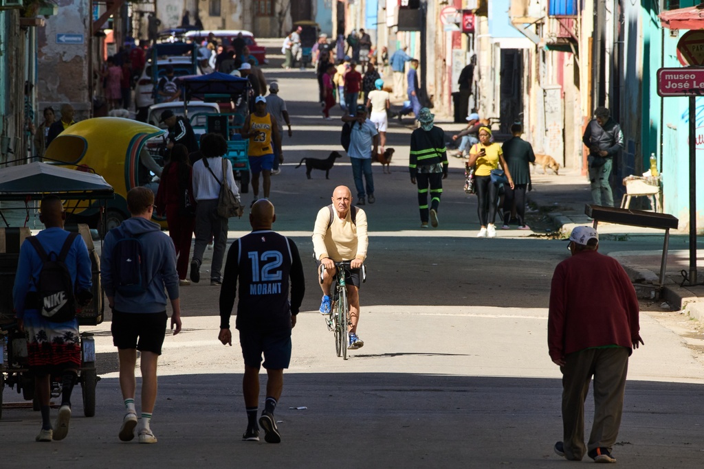 People walk and cycle along a street in Havana, Cuba, Tuesday, Feb. 10, 2026. (AP Photo/Ramon Espinosa)