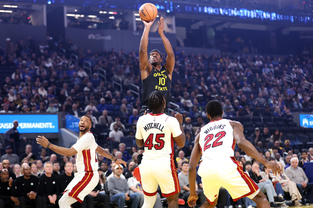 Golden State Warriors' Jimmy Butler III (10) goes up to shoot over Miami Heat's Norman Powell, left, Davion Mitchell (45) and Andrew Wiggins (22) during the first half of an NBA basketball game in San Francisco, Monday, Jan. 19, 2025. (Scott Strazzante/San Francisco Chronicle via AP)