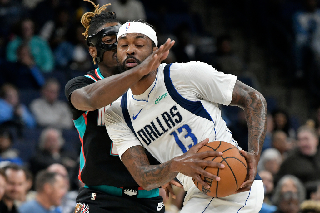 Dallas Mavericks forward Naji Marshall (13) handles the ball against Memphis Grizzlies guard Jahmai Mashack in the first half of an NBA basketball game Thursday, March 12, 2026, in Memphis, Tenn. (AP Photo/Brandon Dill)