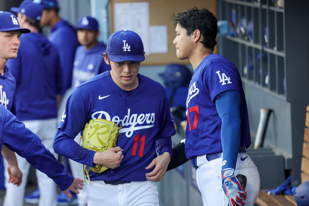 Los Angeles Dodgers starting pitcher Roki Sasaki (11) is greeted by designated hitter Shohei Ohtani, right, after being taken off the mound during the first inning of a spring training baseball game against the Los Angeles Angels, Monday, March 23, 2026, in Los Angeles. (AP Photo/Ryan Sun)