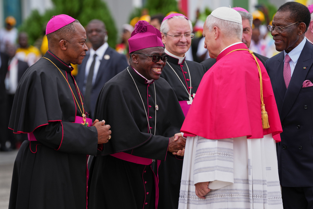 Pope Leo XIV, flanked by Equatorial Guinea's President Teodoro Obiang Nguema Mbasogo, right, is welcomed by Archbishop Juan Nsue Edjang Mayé, left, and Juan Domingo-Beka Esono Ayang upon his arrival at Malabo International Airport in Malabo, Equatorial Guinea, Tuesday, April 21, 2026. (AP Photo/Misper Apawu)