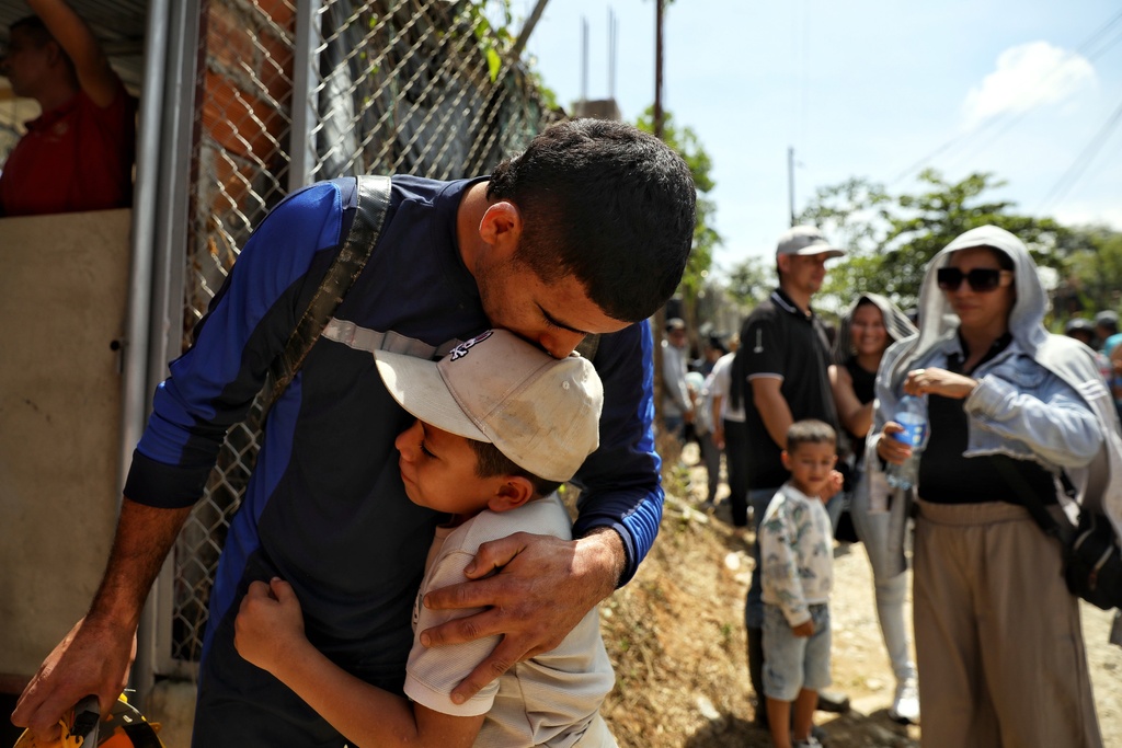 A miner embraces his son after he was rescued from a gold mine he was working in that collapsed, in Segovia, Colombia, Wednesday, Sept. 24, 2025. (AP Photo/Santiago Saldarriaga)