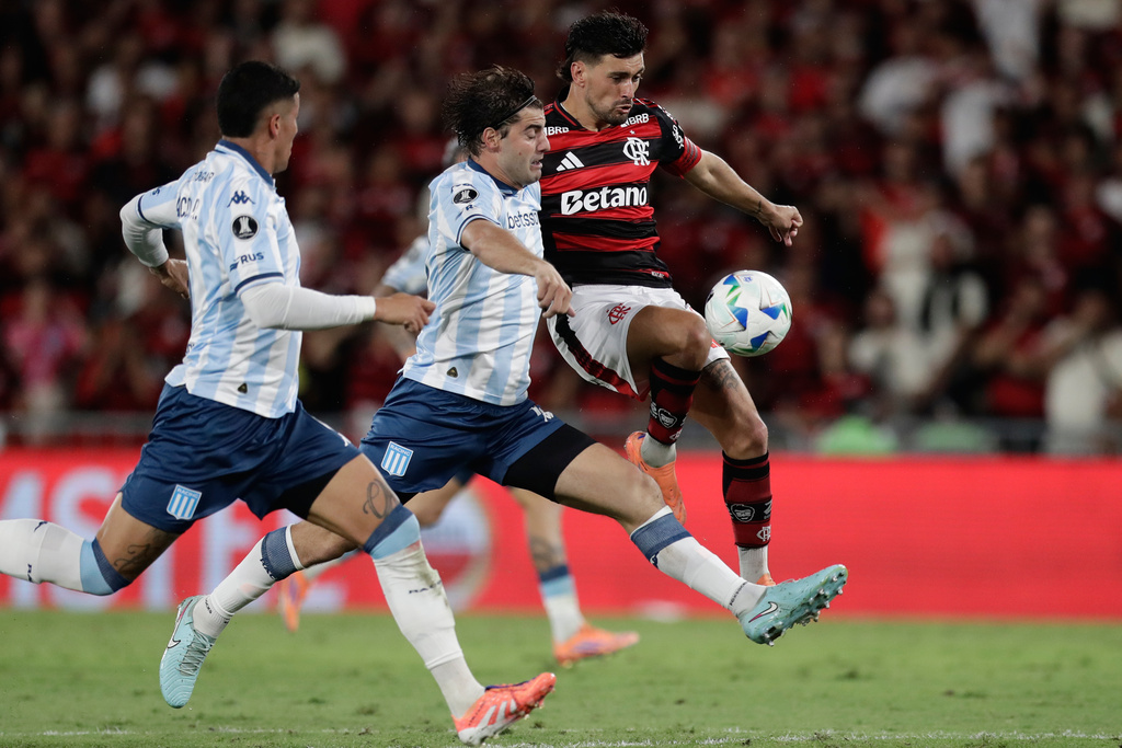 De Arrascaeta of Brazil's Flamengo, right, and Santiago Sosa of Argentina's Racing Club battle for the ball during a Copa Libertadores semifinal first leg soccer match in Rio de Janeiro, Wednesday, Oct. 22, 2025. (AP Photo/Bruna Prado)