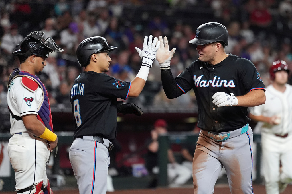 Miami Marlins' Jakob Marsee, right, celebrates his two-run home run with Marlins' Javier Sanoja (8) as Arizona Diamondbacks catcher Gabriel Moreno, left, pauses at home plate during the third inning of a baseball game, Wednesday, Sept. 16, 2026, in Phoenix. (AP Photo/Ross D. Franklin)