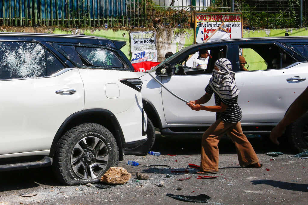 A man attacks a vehicle from an opposing group outside a school used as a polling center during the Bangsamoro Autonomous Region in Muslim Mindanao parliamentary elections in Cotabato city, southern Philippines, Monday, Sept. 14, 2026. (AP Photo)