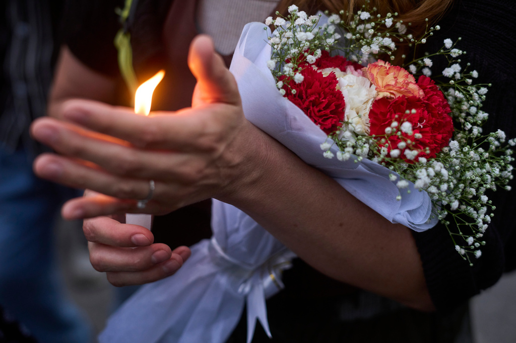 A woman lights candle in memory of the climbers who died Thursday in an avalanche on Pakistan's Broad Peak, Kathmandu, Nepal, Tuesday, Aug. 4, 2026. (AP Photo/Niranjan Shrestha)