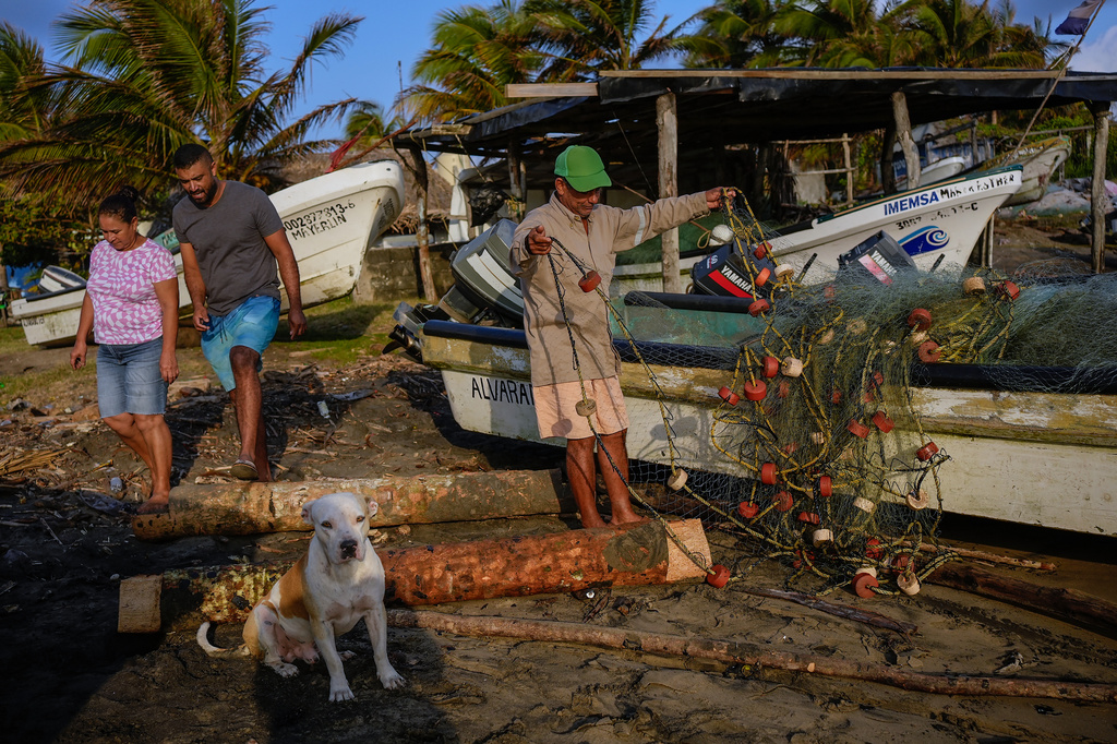 A fisherman untangles a net after suspending fishing outings because of an oil spill in the Gulf of Mexico that authorities said originated from an unidentified vessel and two natural oil seeps in Salinas, Mexico, Thursday, March 26, 2026. (AP Photo/Felix Marquez)