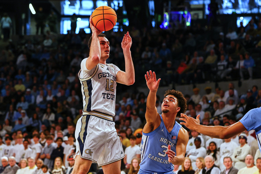 Georgia Tech guard Kam Craft (12) shoots over North Carolina guard Derek Dixon (3) during the first half of an NCAA college basketball game, Saturday, Jan. 31, 2026, in Atlanta. (AP Photo/Colin Hubbard)