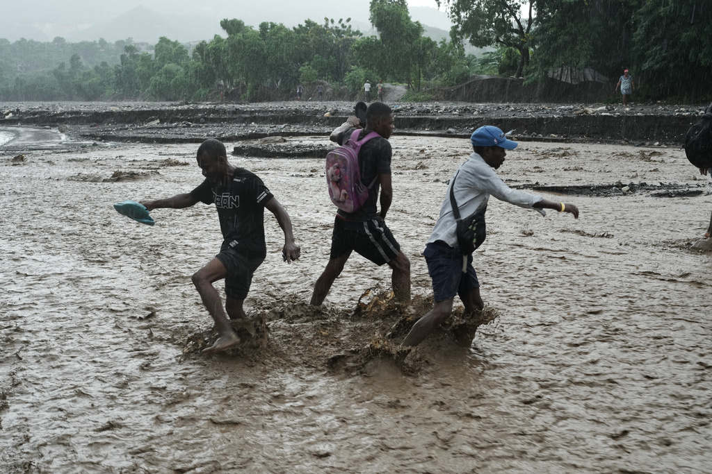 Residents wade through a flooded stream in the aftermath of Hurricane Melissa in Petit-Goave, Haiti, Thursday, Oct. 30, 2025. (AP Photo/Odelyn Joseph)