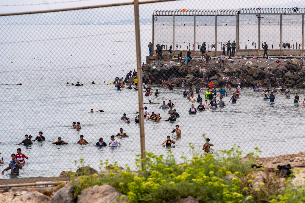 Migrants try to cross from Morocco into the Spanish enclave of Ceuta, Friday, July 31, 2026. (AP Photo/Antonio Sempere)