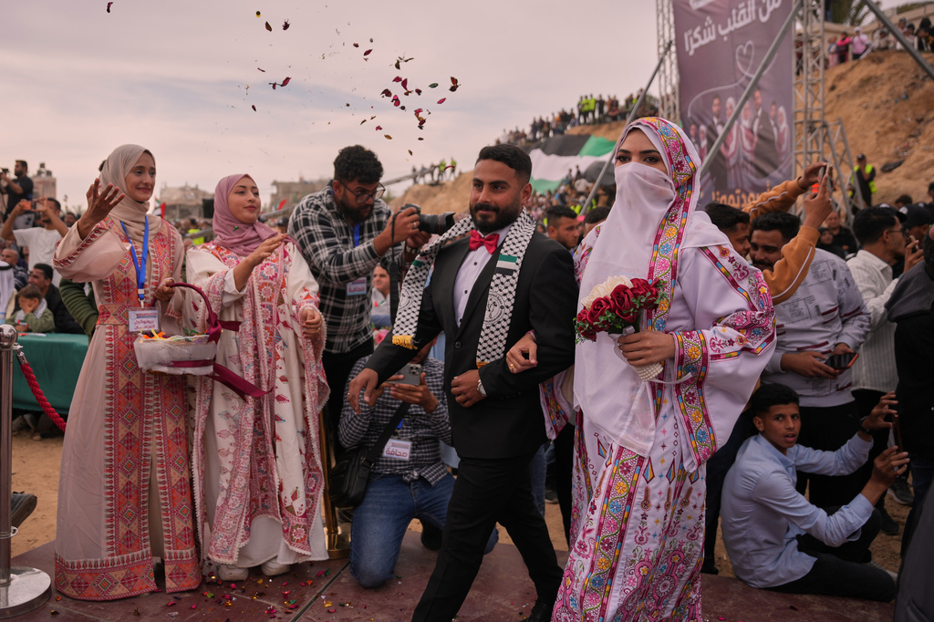 A Palestinian couple participates in a mass wedding ceremony in Deir al-Balah, central Gaza Strip, Friday, April 24, 2026. (AP Photo/Abdel Kareem Hana)