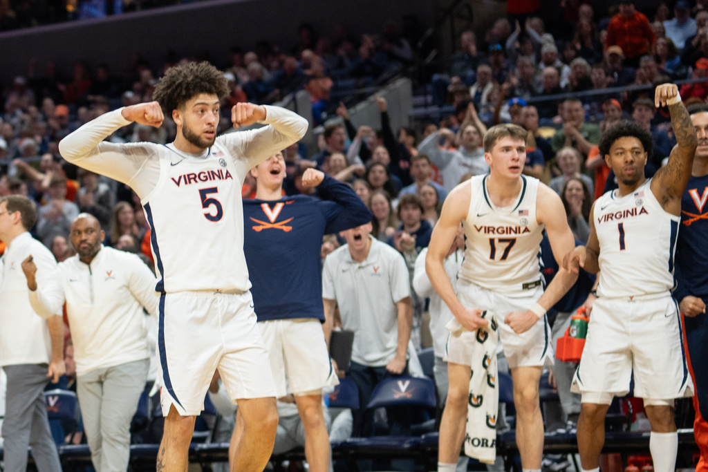 Virginia guard Sam Lewis (5) and the Virginia bench celebrates after a basket during the second half of an NCAA college basketball game against Syracuse, Saturday, Feb. 7, 2026, in Charlottesville, Va. (AP Photo/Robert Simmons)