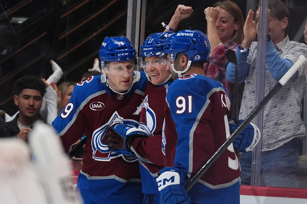Colorado Avalanche center Nathan MacKinnon, left, and right wing T.J. Hughes, center, congratulate center Nazem Kadri (91) after his goal against the Tampa Bay Lightning in the first period of an NHL hockey game Friday, Oct. 23, 2026, in Denver. (AP Photo/David Zalubowski)