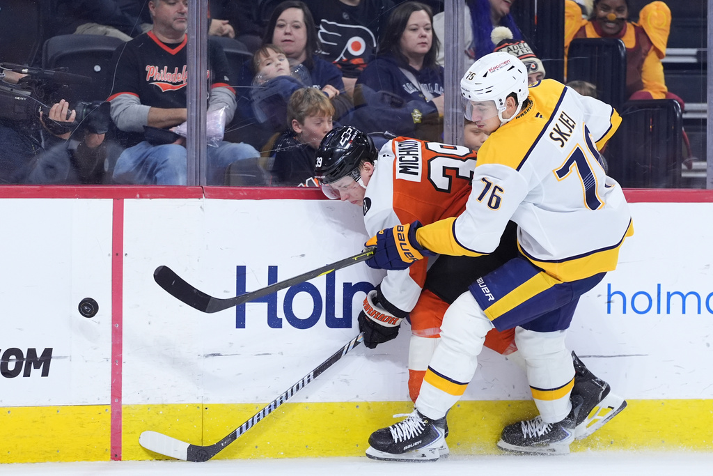 Philadelphia Flyers' Matvei Michkov, left, and Nashville Predators' Brady Skjei battle for the puck during the second period of an NHL hockey game Thursday, Oct. 30, 2025, in Philadelphia. (AP Photo/Matt Slocum)