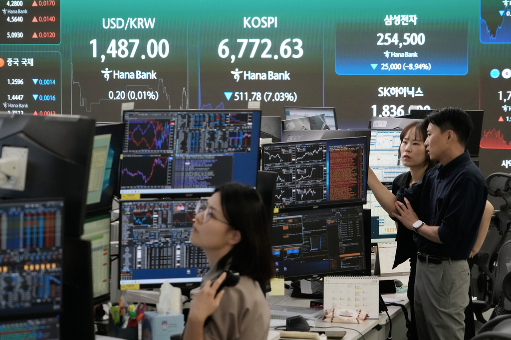 Currency traders work near a screen showing the Korea Composite Stock Price Index (KOSPI) and the foreign exchange rate between U.S. dollar and South Korean won at the foreign exchange dealing room of the Hana Bank headquarters in Seoul, South Korea, Thursday, July 16, 2026. (AP Photo/Ahn Young-joon)