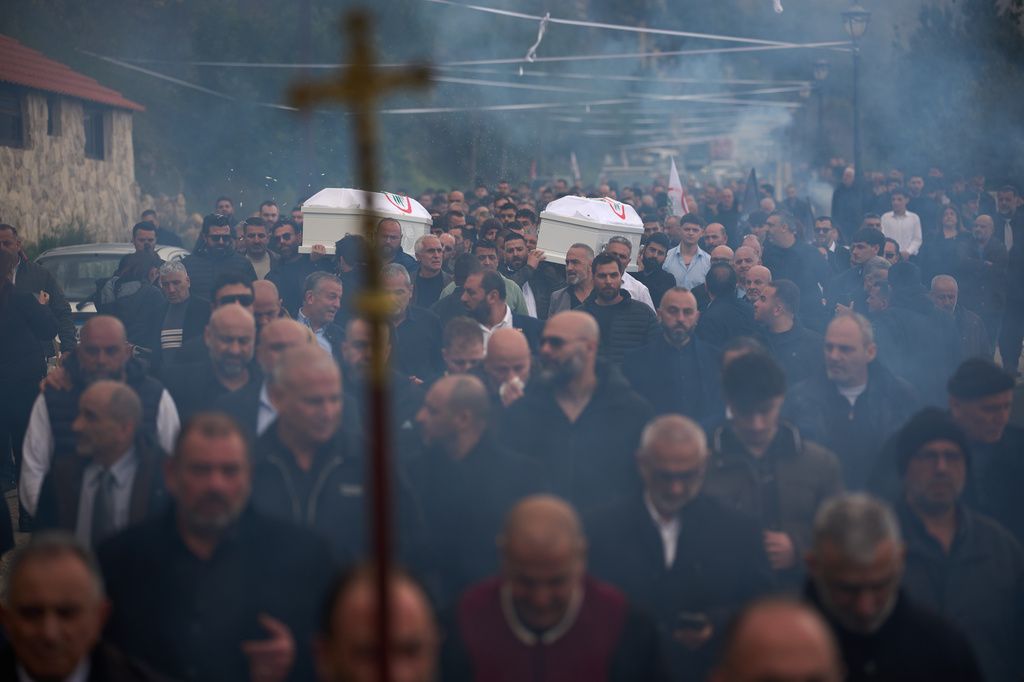 Men carry the coffins with the bodies of Pierre Mouawad, an official with the anti-Hezbollah Lebanese Forces party, and his wife during their funeral in Yahshush, in Lebanon, Tuesday, April 7, 2026. (AP Photo/Emilio Morenatti)