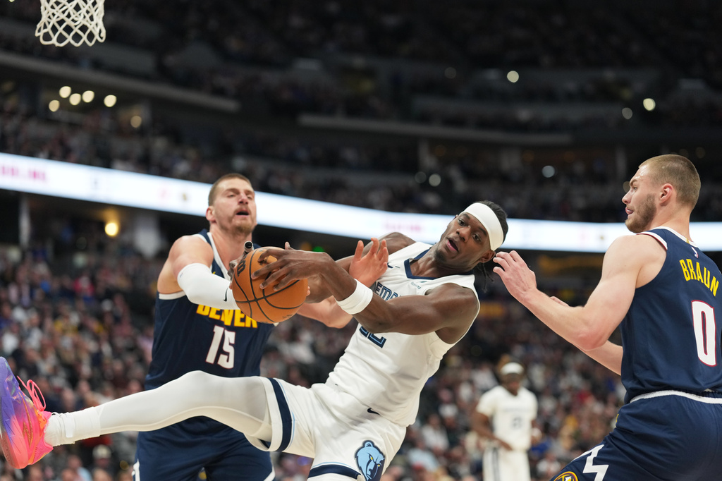 Memphis Grizzlies forward Taylor Hendricks, center, struggles to pull in a loose ball as Denver Nuggets center Nikola Jokić, left, and guard Christian Braun defend in the first half of an NBA basketball game Wednesday, April 8, 2026, in Denver. (AP Photo/David Zalubowski)