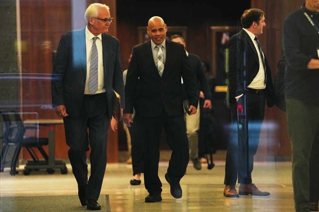 Christian Castro, right, an immigration officer who is accused of shooting a Venezuelan man during the immigration crackdown in Minneapolis early this year and lying to investigators about what happened, leaves with his attorney Daniel Gerdts, left, after a hearing at the Warren E. Burger Federal Building, Friday, Sept. 18, 2026, in St. Paul, Minn. (AP Photo/Ellen Schmidt)