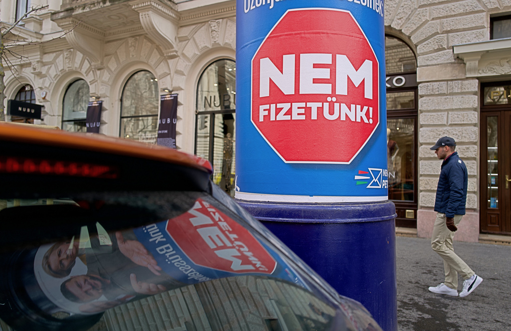 A man passes a billboard that shows an AI-generated image of Ukrainian President Volodymyr Zelenskyy flanked by European officials and reads: "We Don't Pay," in Budapest, Hungary, Monday Feb. 23, 2026. (AP Photo/Bela Szandelszky)