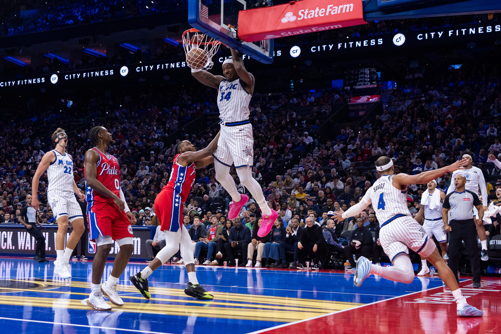 Orlando Magic's Wendell Carter Jr. (34) dunks the ball after taking the pass from Jalen Suggs (4) with Philadelphia 76ers' Jabari Walker, center left, defending during the first half of an NBA Cup basketball game, Tuesday, Nov. 25, 2025, in Philadelphia. (AP Photo/Chris Szagola)
