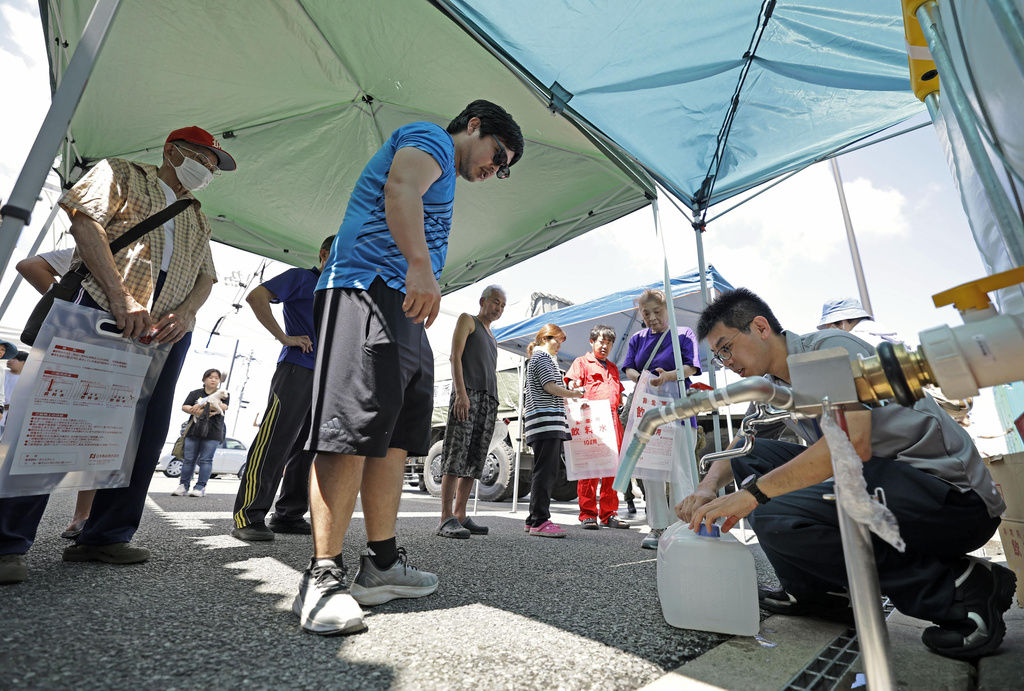 Residents receive water supplies at Hikawa town hall as an earthquake disrupted water service in Hikawa, Kumamoto Prefecture, southern Japan, Friday, July 31, 2026. (Atsuhiro Maeda/Kyodo News via AP)