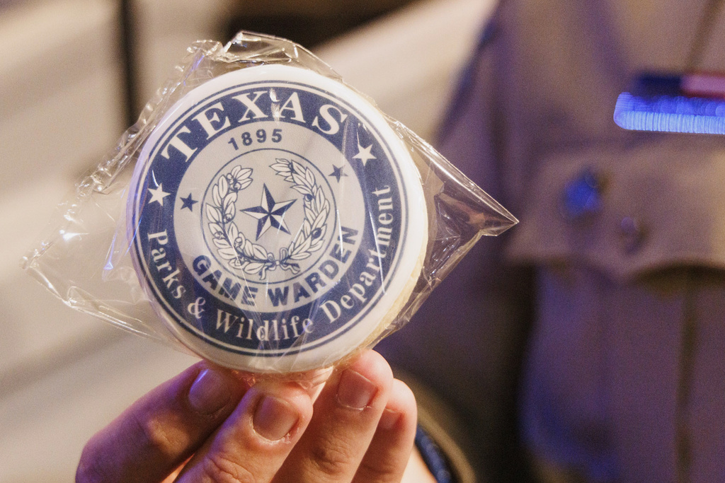 In this photo provided by the Texas Parks and Wildlife Department a person holds up a game warden badge during the 67th Texas Game Warden and State Park Police Officer Commissioning Ceremony on May 30, 2025, in Austin, Texas. (Sonja Sommerfeld/Texas Parks and Wildlife Department via AP)