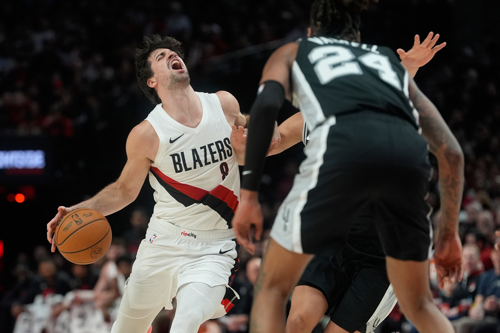 Portland Trail Blazers forward Deni Avdija (8) is fouled as he drives against the San Antonio Spurs during the second half in Game 3 of a first-round NBA playoffs basketball series in Portland, Ore, Friday, April 24, 2026. (AP Photo/Jenny Kane)