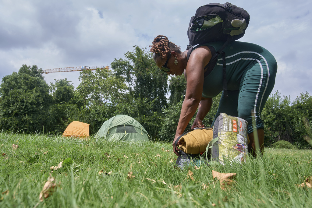 Ms. Jay, of Washington, who lost her job and is living what she calls her "Girl Scout life" while saving money by urban camping and looking for work while homeless, packs up her tent and belongings in a small park by Georgetown, Wednesday, Aug. 13, 2025, in Washington, after being warned by an aid organization that tents are being removed. "Last night was so scary," says Ms. Jay, "I don't want to be the one to wait until the last moment and then have to rush out." (AP Photo/Jacquelyn Martin)