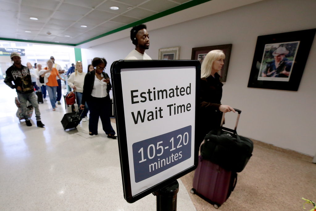 Air travelers wait in line as they progress to the TSA security checkpoint in Terminal A at the George Bush Intercontinental Airport, Monday, March 23, 2026, in Houston. (AP Photo/Michael Wyke)