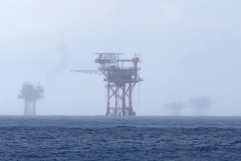 FILE - Oil platforms are visible through the haze near the Flower Garden Banks National Marine Sanctuary in the Gulf of Mexico, off the coast of Galveston, Texas, Sept. 16, 2023. (AP Photo/LM Otero, File)