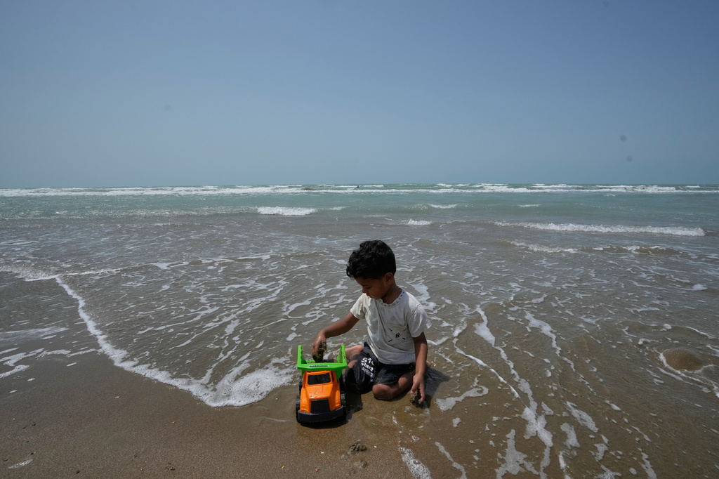 A boy plays with a toy truck on a beach along the Strait of Hormuz in Kuhestak, Iran, Friday, Sept. 4, 2026. (AP Photo/Vahid Salemi)