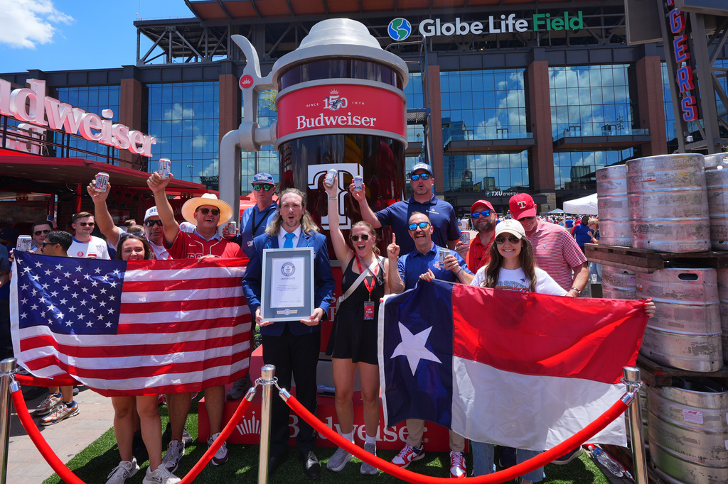 Guinness World Records adjudicator Thomas Bradford, center, cheers with others aftercertifying a world record for Largest Glass of Beer ahead of a baseball game between the Detroit Tigers and Texas Rangers, Saturday, July 4, 2026, in Arlington, Texas. (AP Photo/LM Otero)