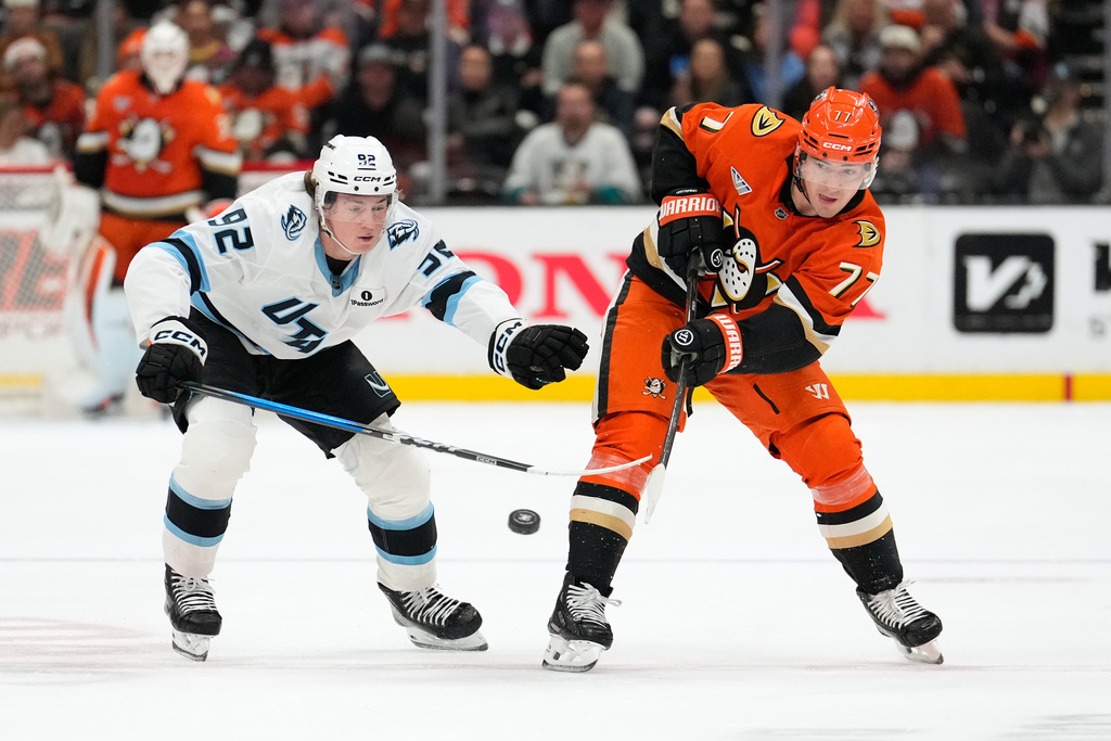 Anaheim Ducks right wing Frank Vatrano, right, passes the puck while under pressure from Utah Mammoth center Logan Cooley during the first period of an NHL hockey game Wednesday, Dec. 3, 2025, in Anaheim, Calif. (AP Photo/Mark J. Terrill)
