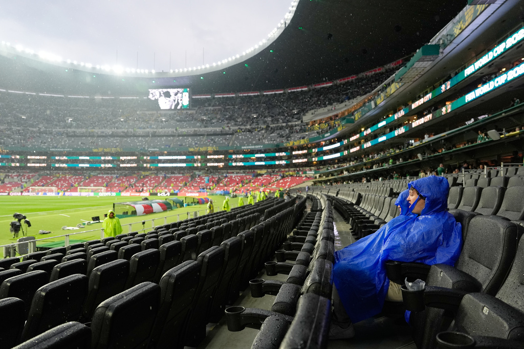 Fans wait as the World Cup round of 32 soccer match between Mexico and Ecuador is delayed due to a thunderstorm, in Mexico City, Tuesday, June 30, 2026. (AP Photo/Fernando Llano)