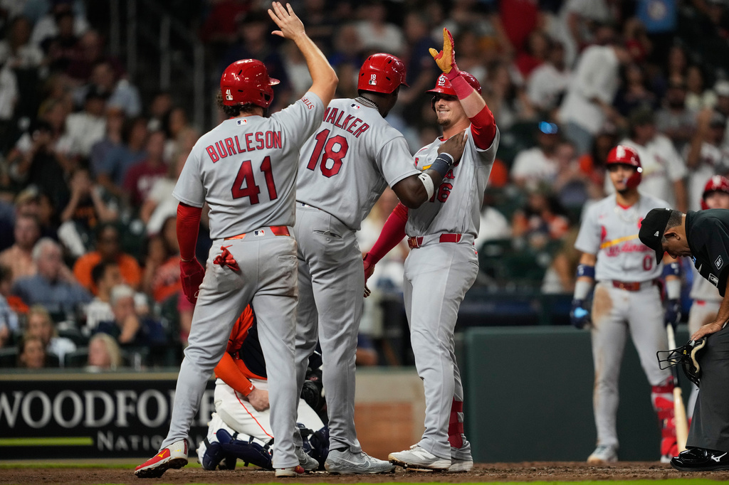 St. Louis Cardinals' Nolan Gorman, right, celebrates with Jordan Walker (18) and Alec Burleson (41) after they all scored from a home run hit by Gorman during the seventh inning of a baseball game against the Houston Astros in Houston, Friday, April 17, 2026. (AP Photo/Ashley Landis)