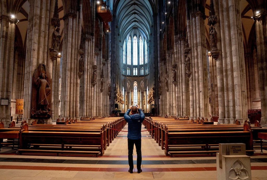 FILE - A tourist takes a picture inside the Cologne Cathedral in Cologne, Germany, Wednesday, Nov. 30, 2022. (AP Photo/Michael Probst, File)