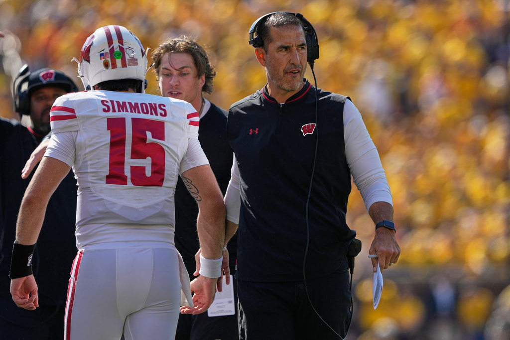 Wisconsin head coach Luke Fickell, right, greets quarterback Hunter Simmons on the sideline during the first half of an NCAA college football game against Michigan, Saturday, Oct. 4, 2025, in Ann Arbor, Mich. (AP Photo/Ryan Sun)
