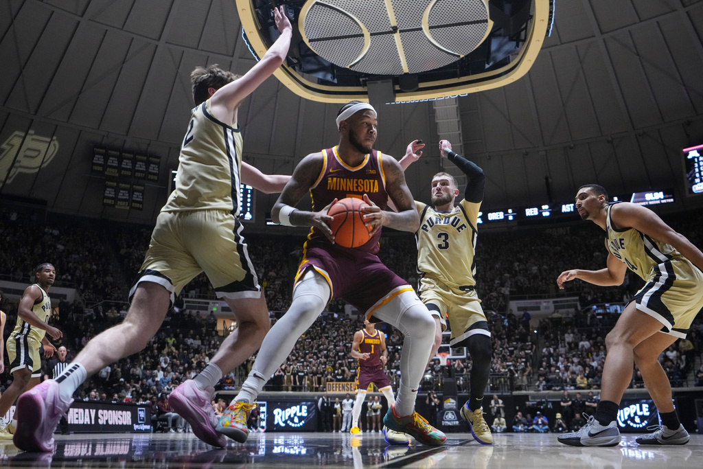 Minnesota forward Jaylen Crocker-Johnson (5) is defended by Purdue center Daniel Jacobsen (12) and guard Braden Smith (3) during the first half of an NCAA college basketball game in West Lafayette, Ind., Wednesday, Dec. 10, 2025. (AP Photo/Michael Conroy)