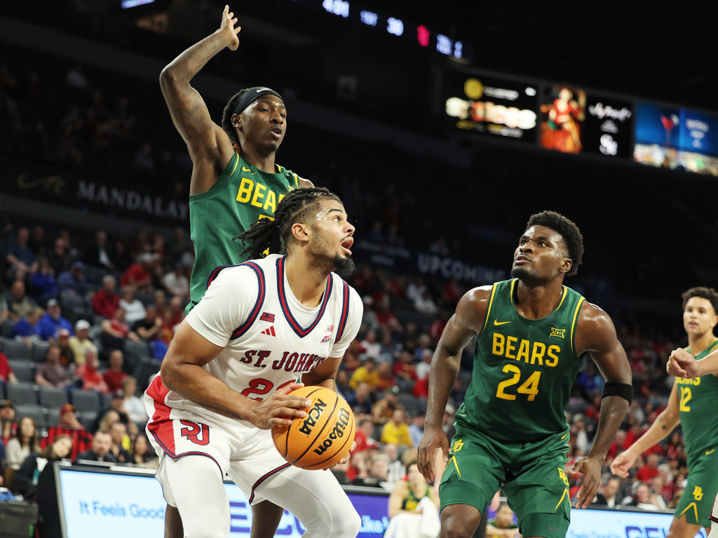St. John's forward Bryce Hopkins (23) grabs a rebound near Baylor guard Obi Agbim (5) and guard Tounde Yessoufou (24) during the first half of an NCAA college basketball game Tuesday, Nov. 25, 2025, in Las Vegas. (AP Photo/Ronda Churchill)