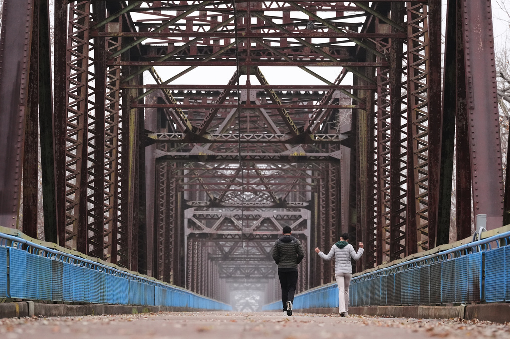 Reygan Calloway, right, and her boyfriend Jordan Smith walk across the Old Chain of Rocks Bridge spanning the Mississippi River from Illinois to Missouri and is now part of the Route 66 Bikeway in Madison, Ill., Thursday, Nov. 20, 2025. (AP Photo/Jeff Roberson)