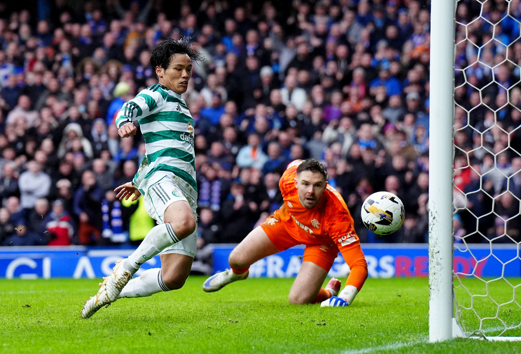 Celtic's Reo Hatate, left, scores his side's second goal during the Scottish Premiership match between Glasgow Rangers and Celtic Glasgow in Glasgow, Scotland, Sunday, March 1, 2026. (Steve Welsh/PA via AP)