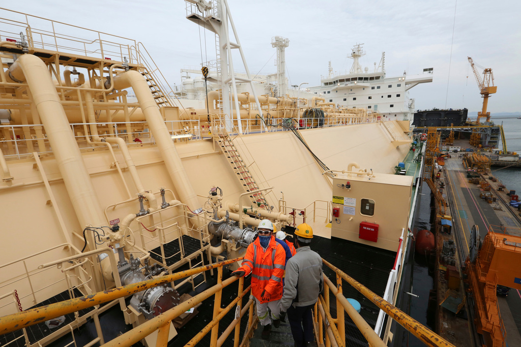 FILE - Workers board large-sized liquefied natural gas (LNG) carriers under construction at the Daewoo Shipbuilding and Marine Engineering facility in Geoje Island, South Korea, Dec. 7, 2018. (AP Photo/Ahn Young-joon, File)
